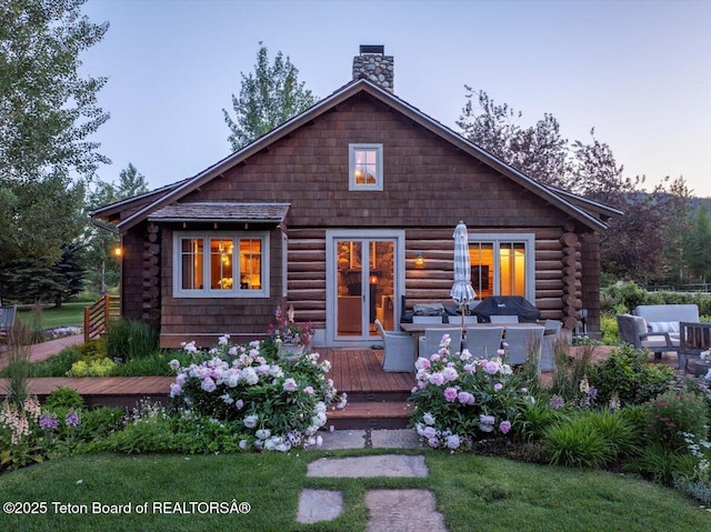 3300 N Trapper Ln, Wilson, WY 83014 - log home featuring a deck, an outdoor hangout area, a chimney, and log siding