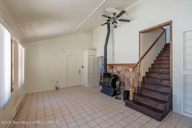 unfurnished living room featuring a wood stove, ceiling fan, baseboard heating, stairway, and vaulted ceiling