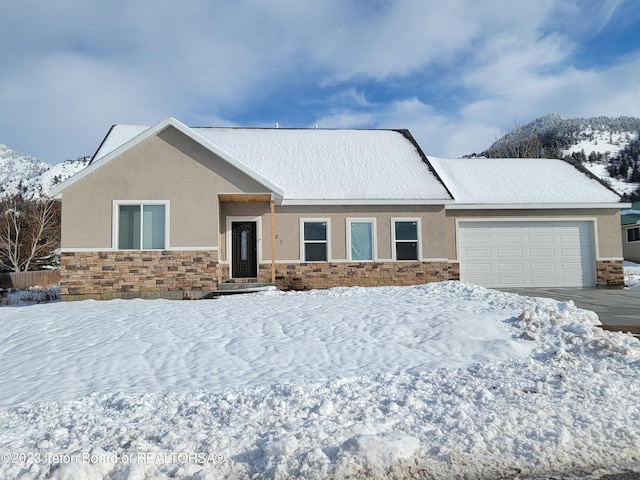 single story home with driveway, a garage, stucco siding, and stone siding