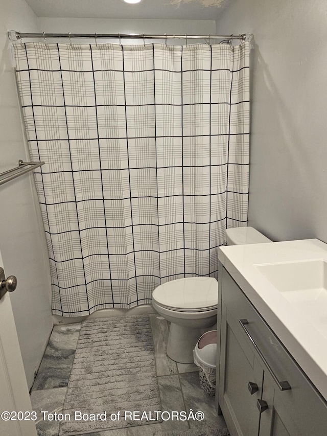 bathroom featuring tile patterned floors, vanity, a shower with curtain, and toilet