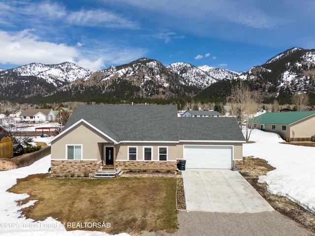 view of front of house featuring a garage, driveway, stucco siding, and stone siding
