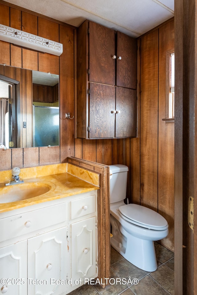 44 12th St, Marbleton, WY 83113 - bathroom with toilet, wood walls, tile patterned flooring, and vanity