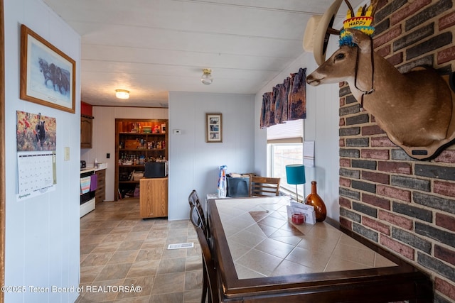 44 12th St, Marbleton, WY 83113 - dining space featuring visible vents and brick wall