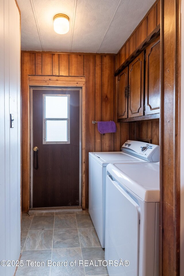 44 12th St, Marbleton, WY 83113 - laundry room with washer and dryer, stone finish flooring, wood walls, and cabinet space