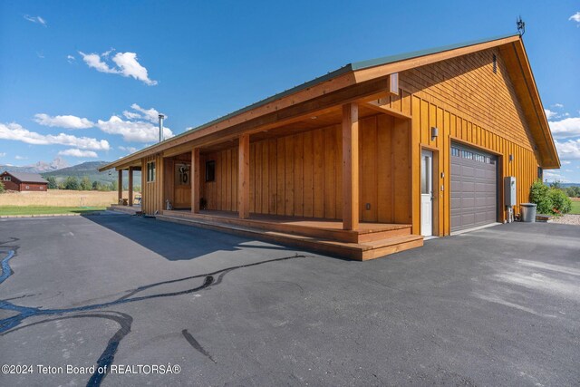1820 Fall Line Dr, Driggs, ID 83422 - view of front of house featuring board and batten siding, a mountain view, and a garage