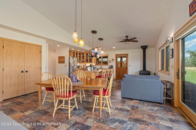 1820 Fall Line Dr, Driggs, ID 83422 - dining space with stone finish flooring, a wood stove, ceiling fan, recessed lighting, and lofted ceiling