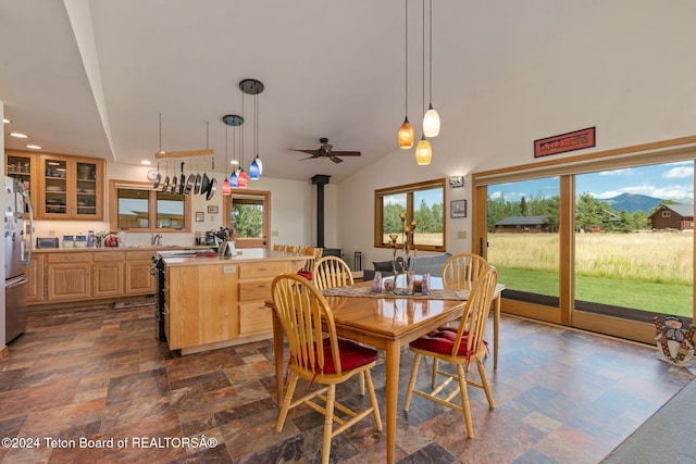 1820 Fall Line Dr, Driggs, ID 83422 - dining space with vaulted ceiling, recessed lighting, a ceiling fan, a wood stove, and stone finish floor