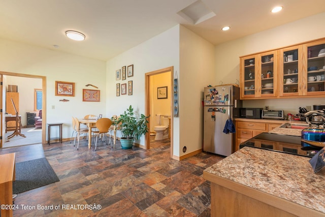 1820 Fall Line Dr, Driggs, ID 83422 - kitchen with stone finish flooring, black appliances, recessed lighting, a sink, and baseboards