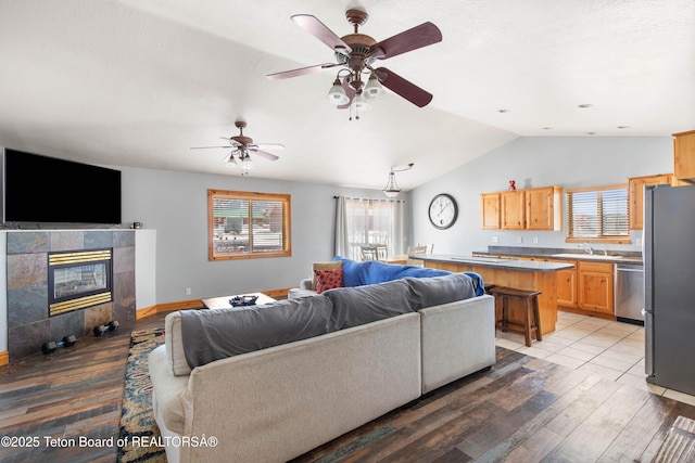 living area featuring plenty of natural light, lofted ceiling, and light wood-type flooring