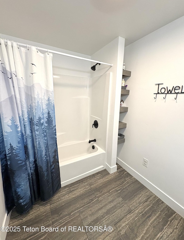 bathroom featuring baseboards, wood finished floors, and shower / bath combination with curtain