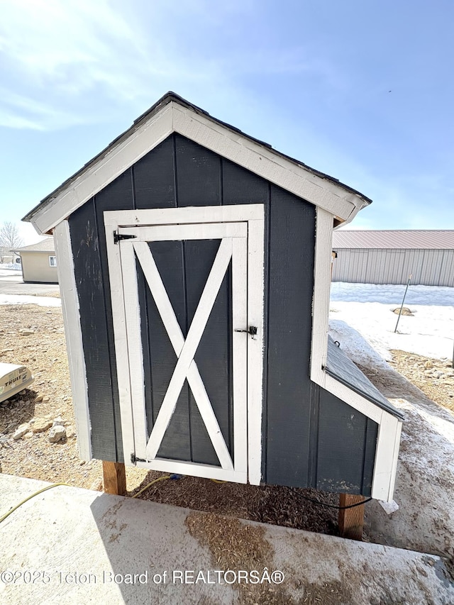 snow covered structure with an outdoor structure and a storage unit
