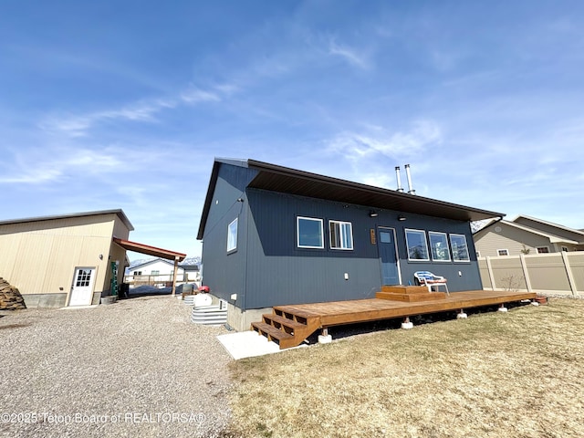 back of property with a wooden deck and fence