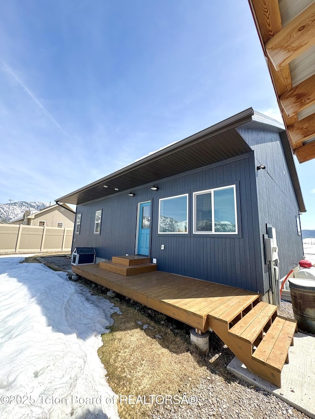 back of house featuring fence and a deck