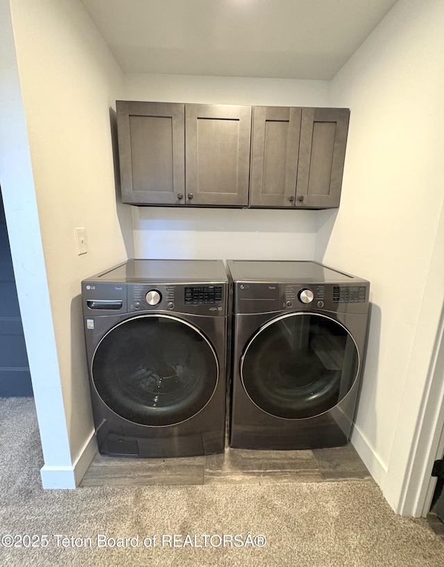 laundry area featuring cabinet space, baseboards, and washing machine and dryer
