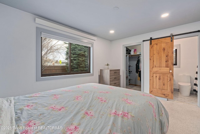 2032 Dandelion Ct, Jackson, WY 83001 - bedroom featuring a walk in closet, a barn door, recessed lighting, carpet floors, and ensuite bath