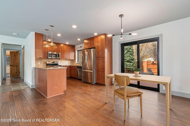 2032 Dandelion Ct, Jackson, WY 83001 - kitchen featuring appliances with stainless steel finishes, dark wood finished floors, brown cabinetry, backsplash, and recessed lighting