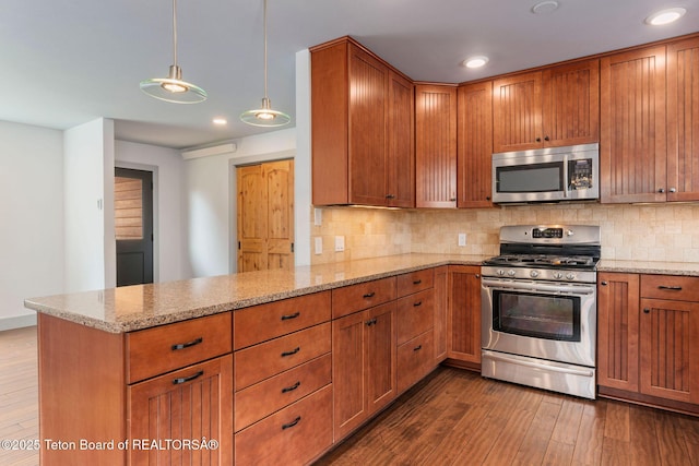 2032 Dandelion Ct, Jackson, WY 83001 - kitchen with appliances with stainless steel finishes, a peninsula, dark wood finished floors, tasteful backsplash, and recessed lighting