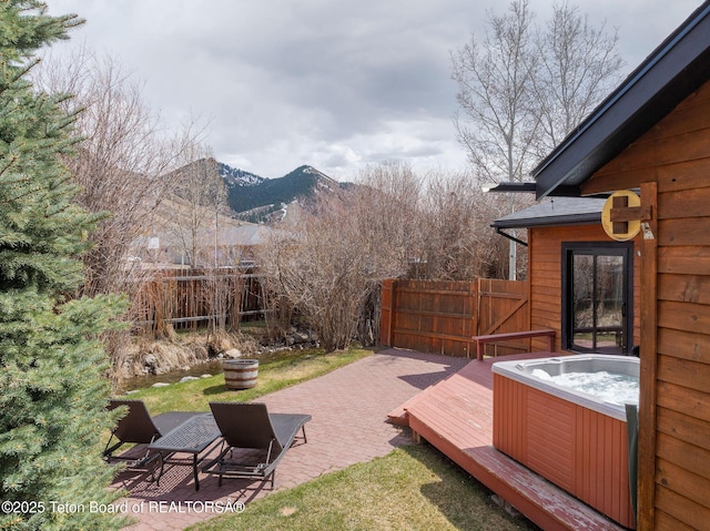 2032 Dandelion Ct, Jackson, WY 83001 - view of yard featuring a hot tub, fence, a deck with mountain view, and a patio area