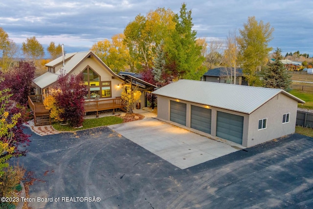 17 C B Ln, Pinedale, WY 82941 - view of front of property featuring a detached garage, stucco siding, an outbuilding, metal roof, and a wooden deck