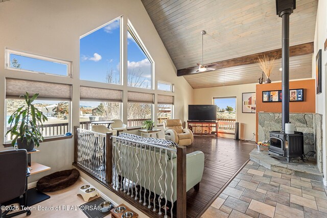 17 C B Ln, Pinedale, WY 82941 - living area featuring a wood stove, high vaulted ceiling, wood ceiling with exposed beams, baseboards, and wood finished floors