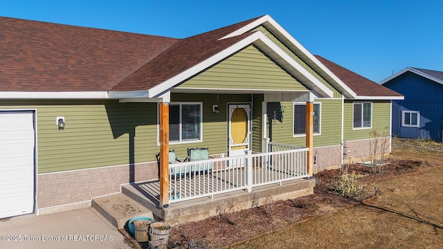 view of front of home with roof with shingles and covered porch