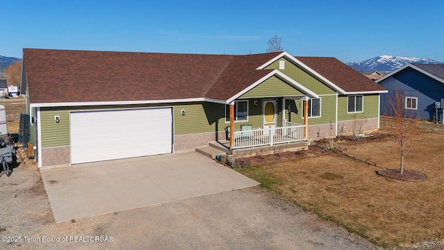 view of front of property with driveway, a shingled roof, covered porch, an attached garage, and a mountain view