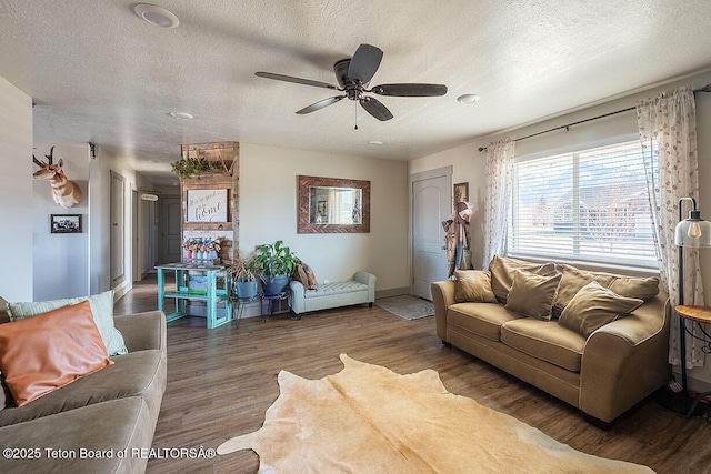 living room with wood finished floors, a textured ceiling, baseboards, and ceiling fan