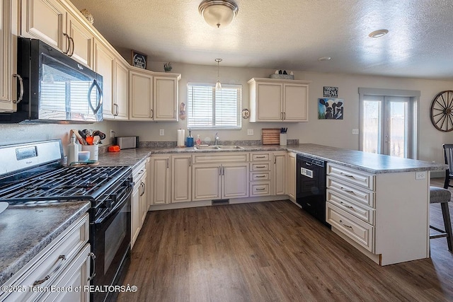 kitchen featuring a sink, a textured ceiling, black appliances, dark wood finished floors, and a peninsula