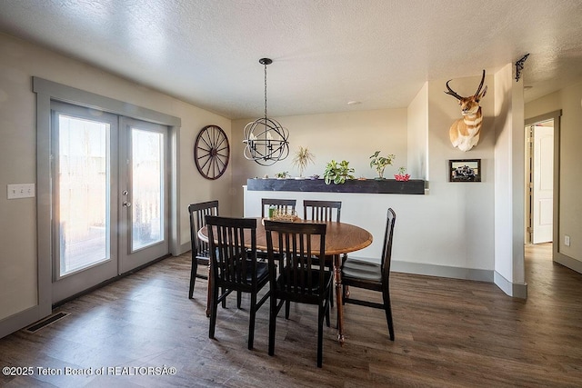 dining space with dark wood finished floors, visible vents, baseboards, and french doors