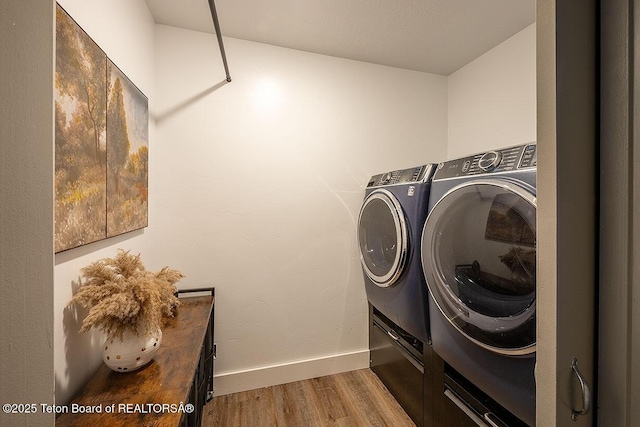 washroom with washer and dryer, baseboards, laundry area, and light wood-style flooring