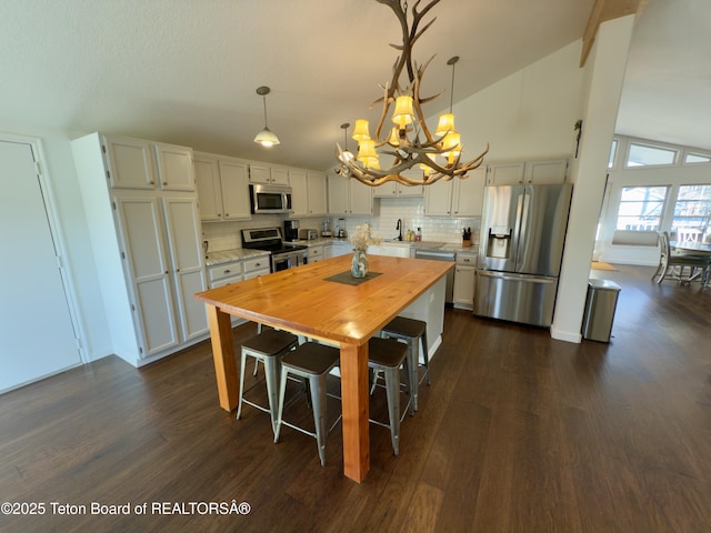 3048 Rangeview Dr, Jackson, WY 83001 - kitchen with a chandelier, tasteful backsplash, appliances with stainless steel finishes, and wooden counters
