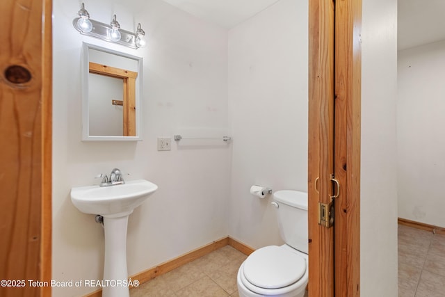 708 Palisades Ln, Alpine, WY 83128 - half bath featuring tile patterned floors, baseboards, a sink, and toilet