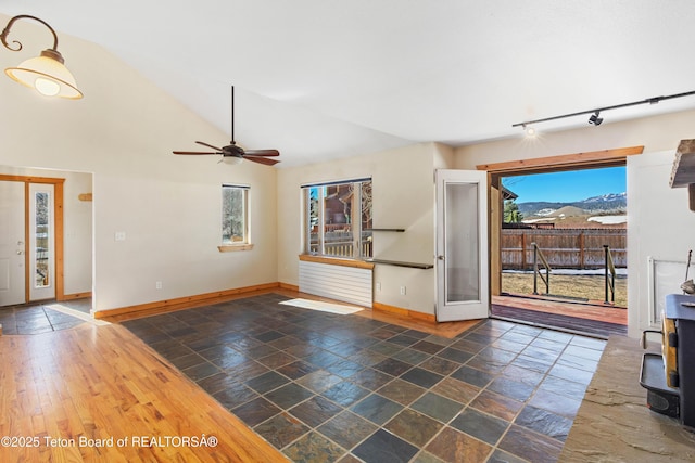 708 Palisades Ln, Alpine, WY 83128 - unfurnished living room featuring track lighting, baseboards, a ceiling fan, and lofted ceiling