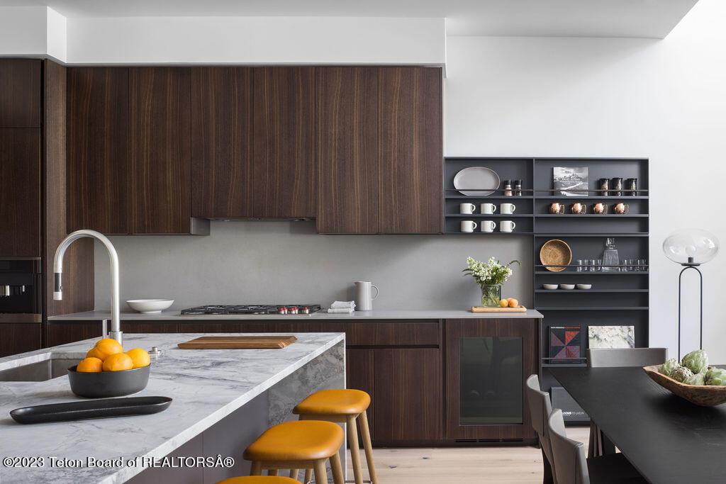 kitchen featuring a breakfast bar, dark brown cabinetry, modern cabinets, and a sink