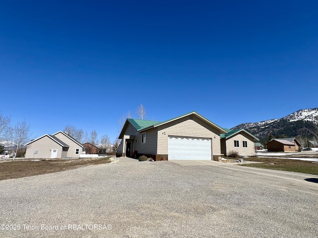 view of side of home with a mountain view, a garage, and concrete driveway