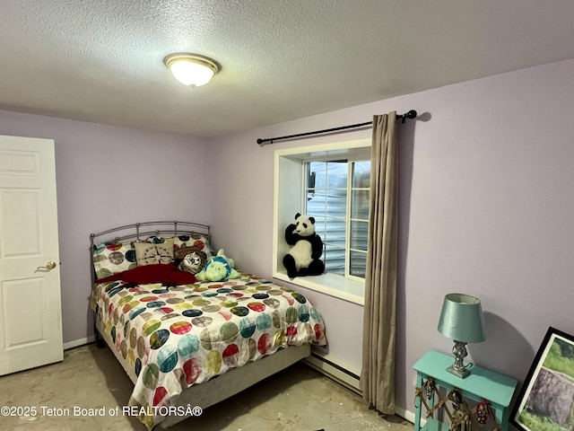 bedroom with concrete floors, a baseboard heating unit, and a textured ceiling