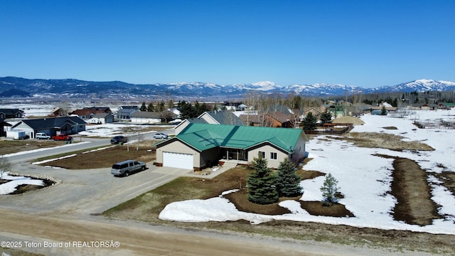 snowy aerial view with a mountain view and a residential view