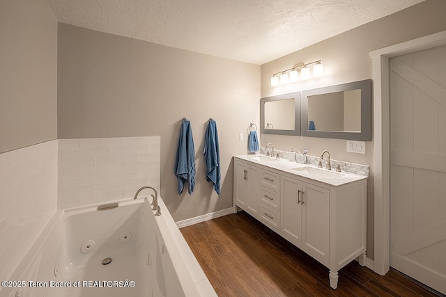 102295 US Highway 89, Thayne, WY 83127 - full bath featuring a textured ceiling, wood finished floors, baseboards, a jetted tub, and double vanity