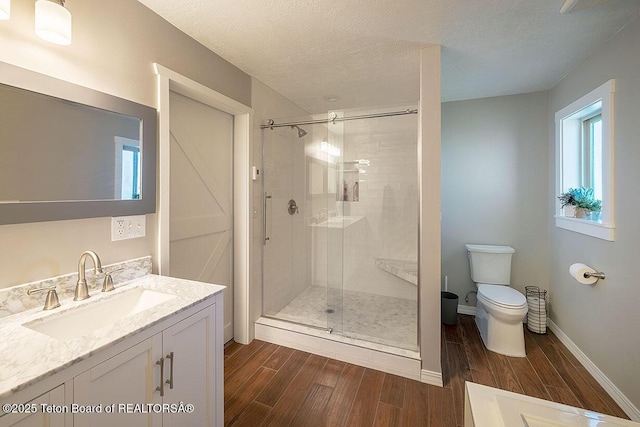 102295 US Highway 89, Thayne, WY 83127 - full bathroom featuring wood finished floors, a stall shower, healthy amount of natural light, toilet, and a textured ceiling