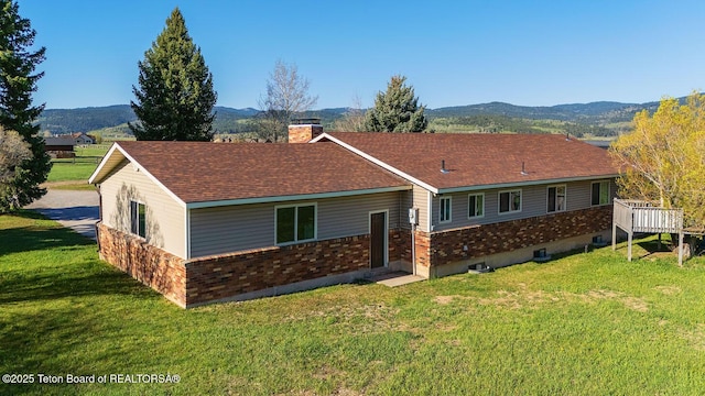 102295 US Highway 89, Thayne, WY 83127 - rear view of house featuring a chimney, a lawn, a mountain view, and a shingled roof