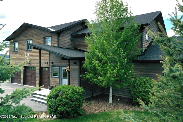 9075 Nesting Eagles Loop, Victor, ID 83455 - view of front of house featuring an attached garage, roof with shingles, and asphalt driveway