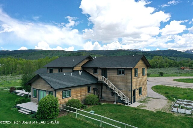 9075 Nesting Eagles Loop, Victor, ID 83455 - rear view of property with driveway, a mountain view, a shingled roof, and a forest view