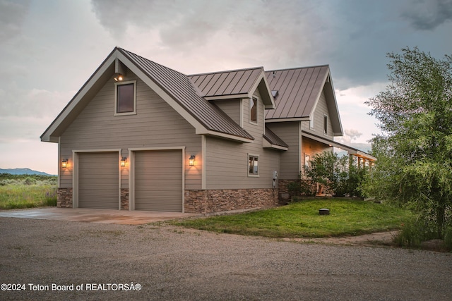 view of side of property featuring stone siding, a standing seam roof, dirt driveway, and metal roof
