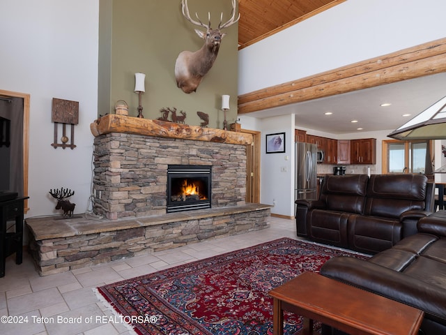 living area with recessed lighting, a stone fireplace, a high ceiling, and light tile patterned flooring
