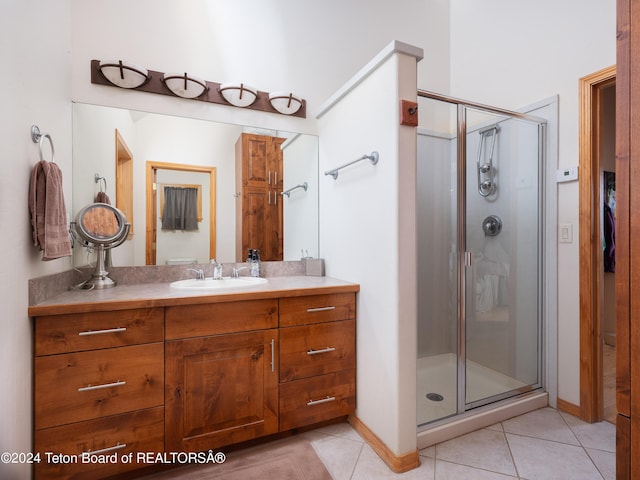full bath featuring vanity, tile patterned flooring, and a stall shower