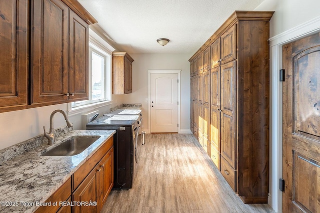 laundry area featuring cabinet space, washer and clothes dryer, and light wood-type flooring