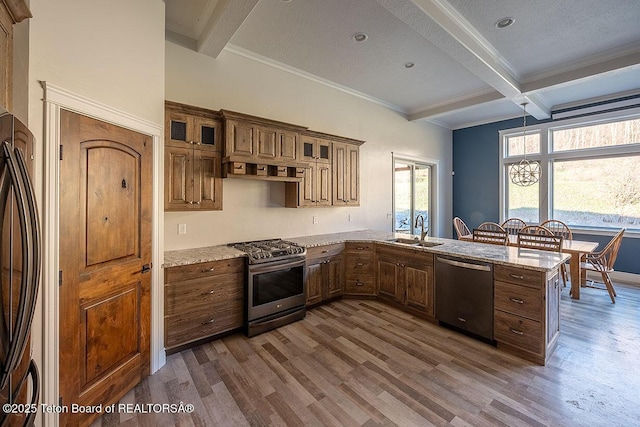 kitchen featuring appliances with stainless steel finishes, a sink, beamed ceiling, dark wood-style floors, and a peninsula