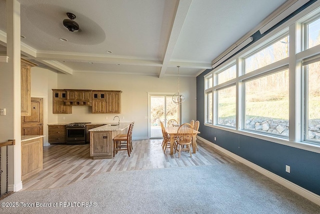 dining area featuring beamed ceiling, plenty of natural light, baseboards, coffered ceiling, and light wood finished floors