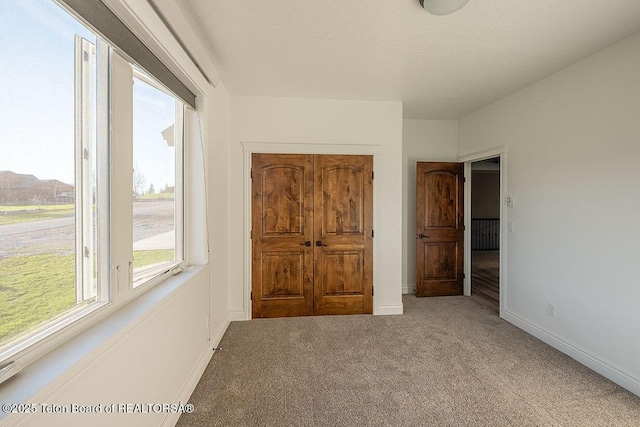 unfurnished bedroom featuring carpet and baseboards
