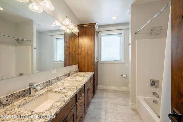 bathroom with plenty of natural light, double vanity, baseboards, and shower / washtub combination